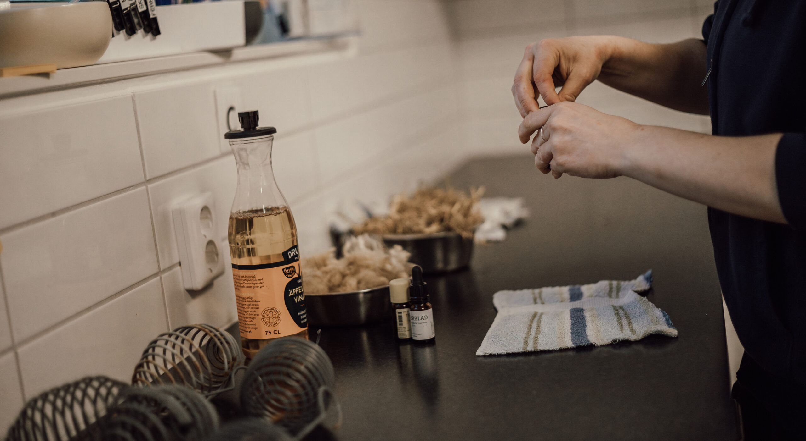 En person som står i ett kök och förbereder berikning till hundar.