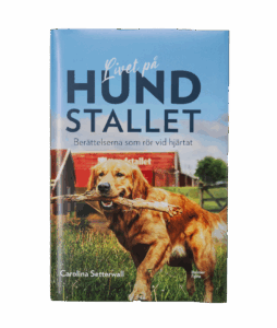En bok med en hund som håller en pinne i munnen.
